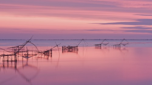 fishermen with yellow and orange sun in the background